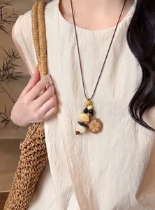 Detailed shot of an ethnic style wooden cat pendant necklace with beaded leather cord