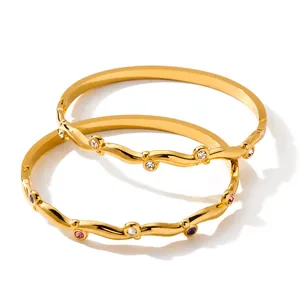 Dettaglio ravvicinato del bracciale dorato irregolare con intarsi di zirconi colorati