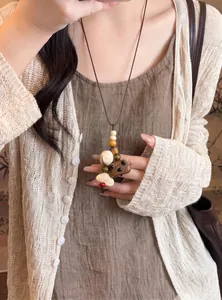 Close-up of a handcrafted Neo-Chinese style wooden beaded pendant necklace on a model.