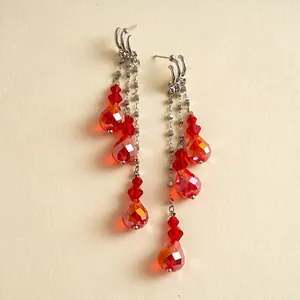 Vue détaillée de boucles d'oreilles rétro élégantes à pompons en cristal rouge
