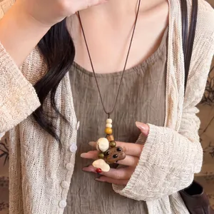 Handcrafted wooden bear pendant necklace with colorful beads on durable brown leather cord