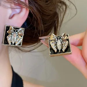 Close-up detail of vintage butterfly stud earrings with black enamel and crystal inlay