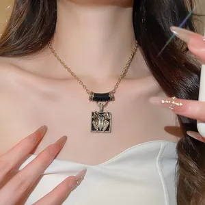 Detailed view of a vintage oil-dripped butterfly pendant necklace worn by a model