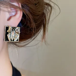 Detailed close-up of a vintage butterfly stud earring featuring black enamel and rhinestones