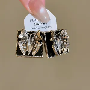 Detailed view of vintage-style butterfly earrings with black enamel and sparkling crystals