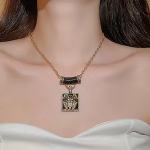 Detailed view of a vintage gold-tone necklace featuring a rhinestone butterfly square pendant