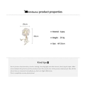 Detail showing dimensions and material of the white fabric floral tassel scrunchie