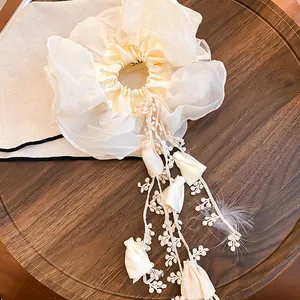 Close-up of elegant double-layer organza scrunchie with long floral tassel detail