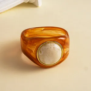 Nahaufnahme eines Retro-Acryl-Armreifs mit Bernsteinmarmorierung und weißem Harzkern