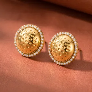 Gedetailleerde weergave van 18k goud vergulde oorknopjes met een halo van strass.