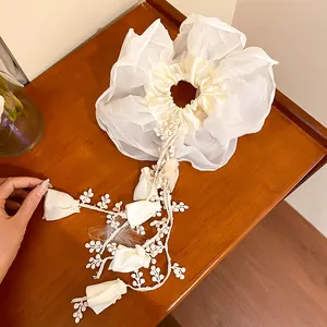 Detail view of a white double-layer fabric scrunchie with elegant tassel floral ornaments