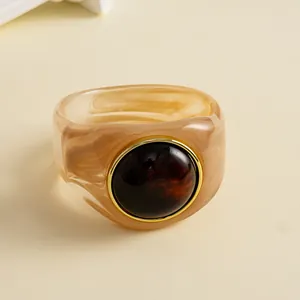 Nahaufnahme eines Vintage-Armreifs aus marmoriertem Acryl mit dunkelbraunem Stein