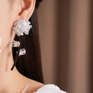 Detailed view of elegant handmade crystal glass flower tassel earrings on a model
