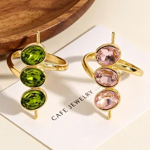Detailansicht der vergoldeten offenen Ringe mit drei ovalen grünen und rosa Zirkonia.