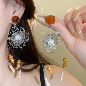 Macro detail of New Chinese style retro floral tassel earrings with resin beads and pearls.