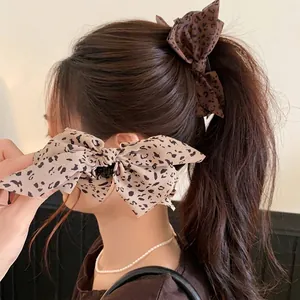 Elegante haarklem met stoffen luipaardprint strik en een modieus retro ontwerp