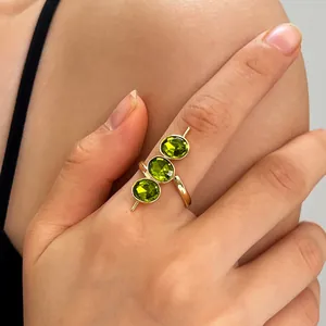 Detailansicht eines vintage goldenen Rings mit drei grünen Zirkonen an der Hand
