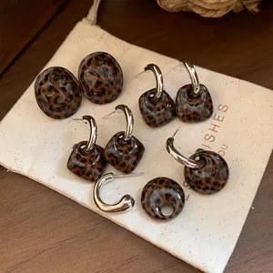 Nahaufnahme von Vintage-Ohrringen mit Leopardenmuster auf einem Stoffbeutel für Schmuck.