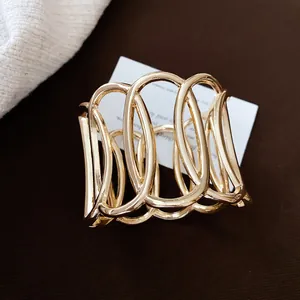 Detailansicht eines goldfarbenen hohlen ovalen offenen Armreifs für modebewusste Damen.