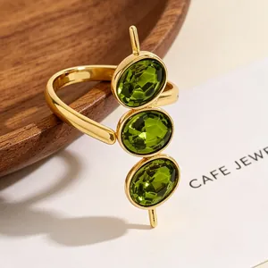 Detaillierte Nahaufnahme von drei grünen Zirkonia in einem goldenen Ring
