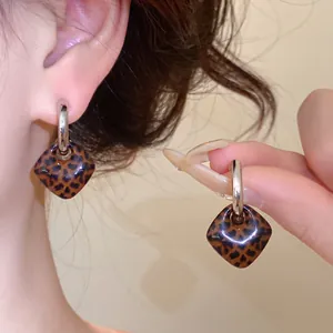Detailaufnahme von Vintage Retro Ohrringen mit Leopardenmuster und Silberreifen