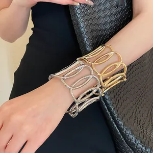 Nahaufnahme von gold- und silberfarbenen, ovalen, hohlen Manschettenarmbändern