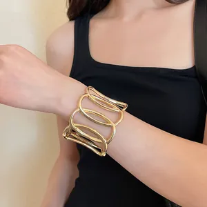 Detailansicht eines breiten goldenen hohlen ovalen Armbands mit edler Metallstruktur
