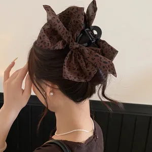 Detailansicht einer modischen Haarspange mit Leopardenmuster-Schleife für elegante Frisuren.