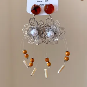 Detail view of New Chinese retro flower tassel earrings with amber resin and pearls