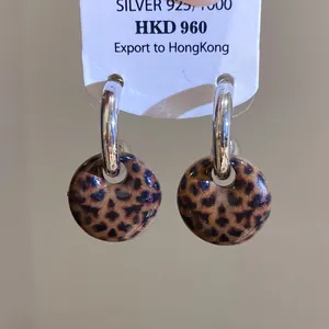 Detailaufnahme von Vintage-Creolen mit runden Anhängern im Leopardenmuster-Design