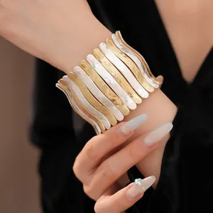 Bracelet manchette métallique plissé avec des barres verticales ondulées or et argentées