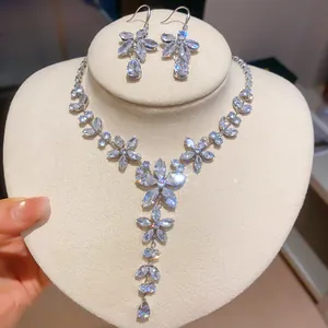 Detailopname van sprankelende zirkonia bloemenketting en oorbellen set op witte buste