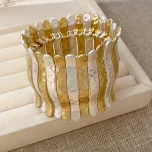 Détail du bracelet manchette élastique bicolore or et argent martelé avec texture métal
