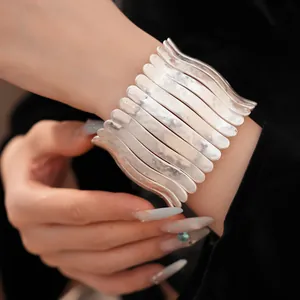 Gros plan d'un bracelet métallique plissé argenté chic avec une texture martelée unique