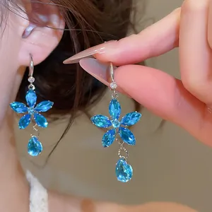 Detailweergave van fonkelende blauwe zirkoon bloemoorbellen met elegante druppelhanger