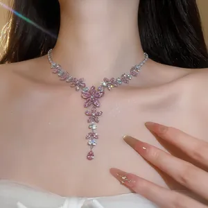 Gedetailleerd zijaanzicht van een fonkelende roze zirkoon bloemenketting op de nek
