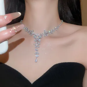 Detailopname van sprankelende zirkoon bloemenketting met waterdruppel hanger op model