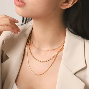 Close-up view of a triple layered 18K gold plated stainless steel necklace on a model