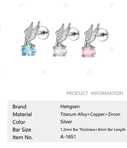 Close-up detail of angel wing cartilage stud earrings with titanium alloy and zirconia