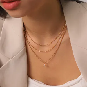 Detailed shot of a triple-layered 18K gold plated stainless steel necklace on model