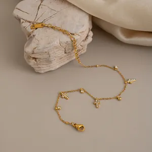 Detail van 18-karaats vergulde roestvrijstalen armband met kruishangers van zirkonia.