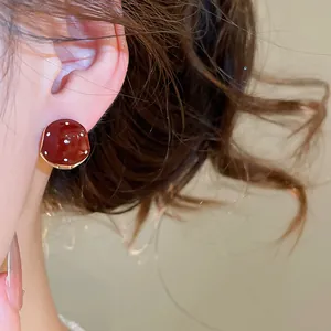 Close-up of retro Maillard style red polka dot oil-dripping stud earring on model's ear