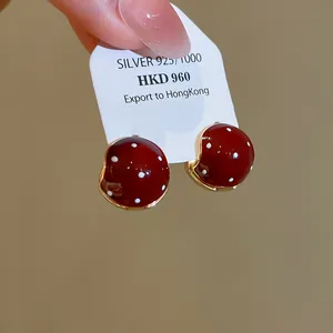 Detailed view of vintage red polka dot enamel earrings on S925 silver display card