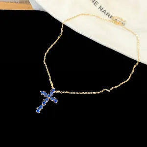 Vista detallada del collar chapado en oro de 18k con colgante de cruz de circón azul