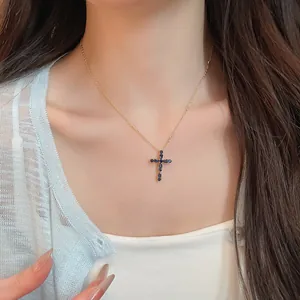 Vista detallada de collar de cruz bañada en oro de 18k con circonitas azules en el cuello.