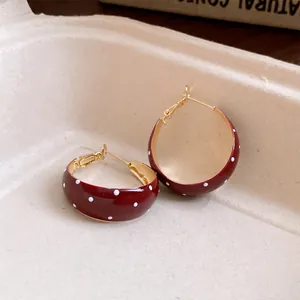 Macro view of vintage red enamel hoop earrings with a classic white polka dot pattern