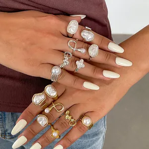 Close-up of retro irregular geometric pearl rings set in gold and silver finish