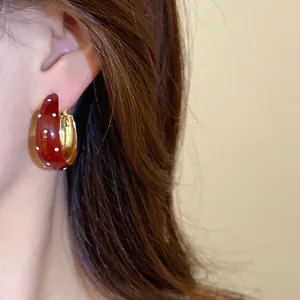 Close-up view of vintage red polka dot hoop earrings with a glossy drop oil finish