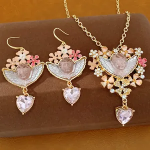 Vista dettagliata del set collana e orecchini angelo con cristalli a forma di cuore rosa