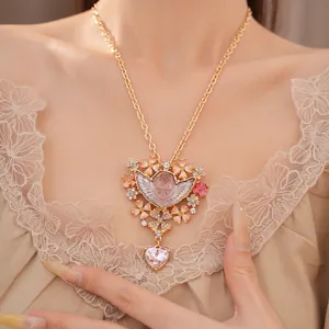 Primo piano di una squisita collana vintage con angelo e cuore rosa sulla modella